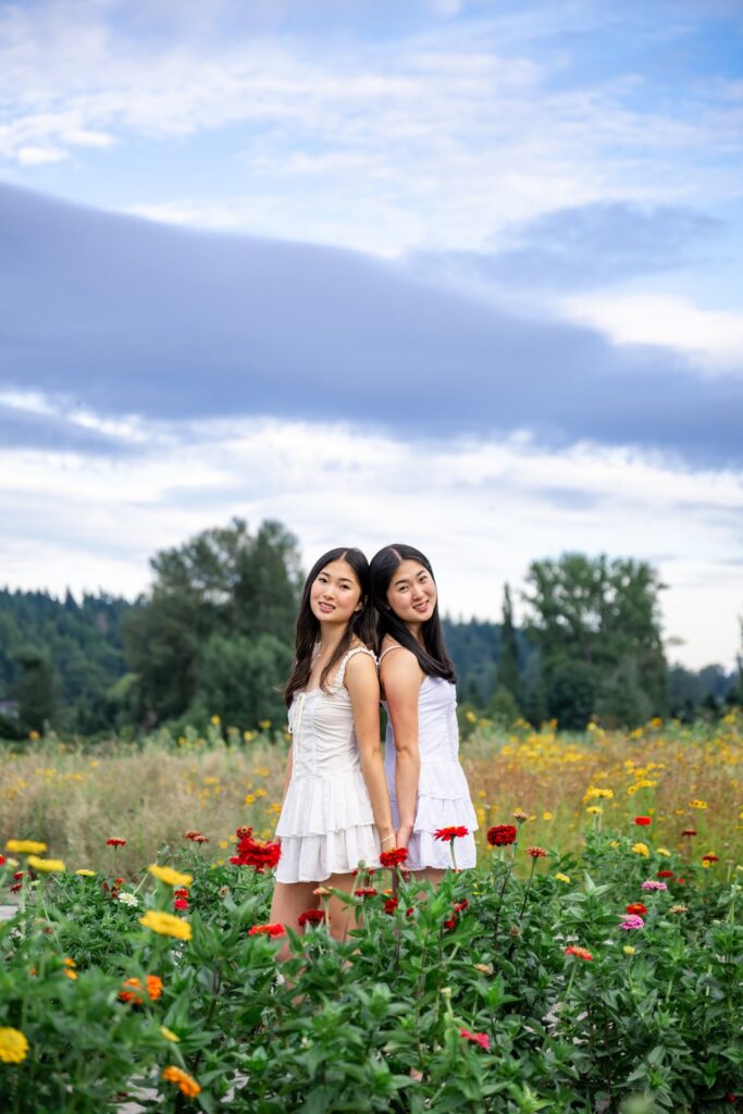 senior twins in white dresses at woodinville flower field