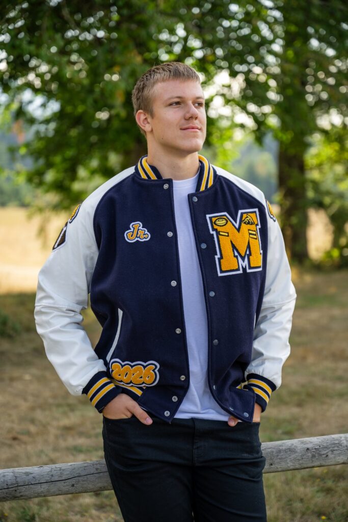 senior guy with letterman jacket at north bend park