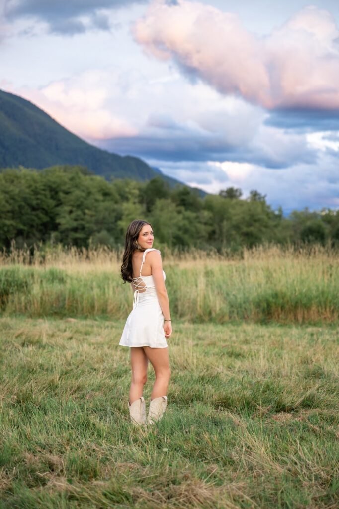 north bend senior girl white dress and cowboy boots with mountain