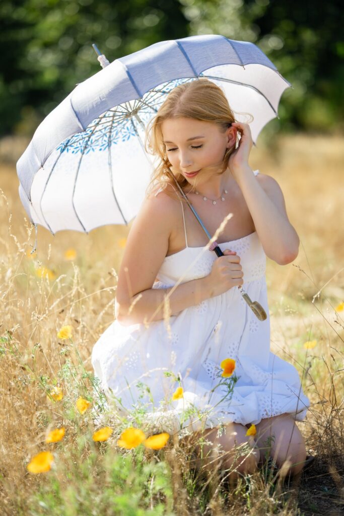 high school senior girl white dress seated pose yellow flowers