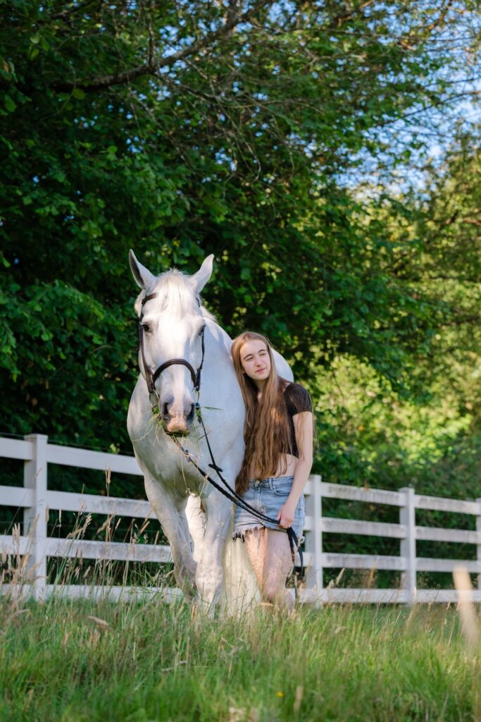 senior girl with white horse in field
