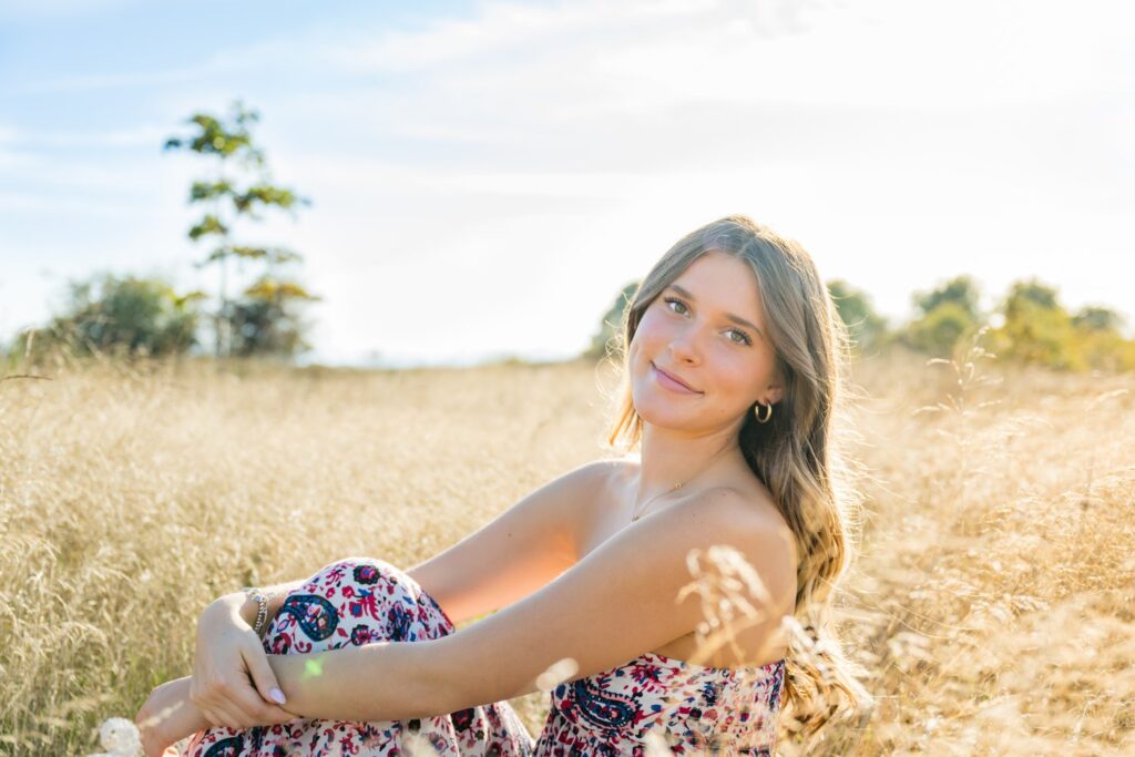 seated senior picture wheat field