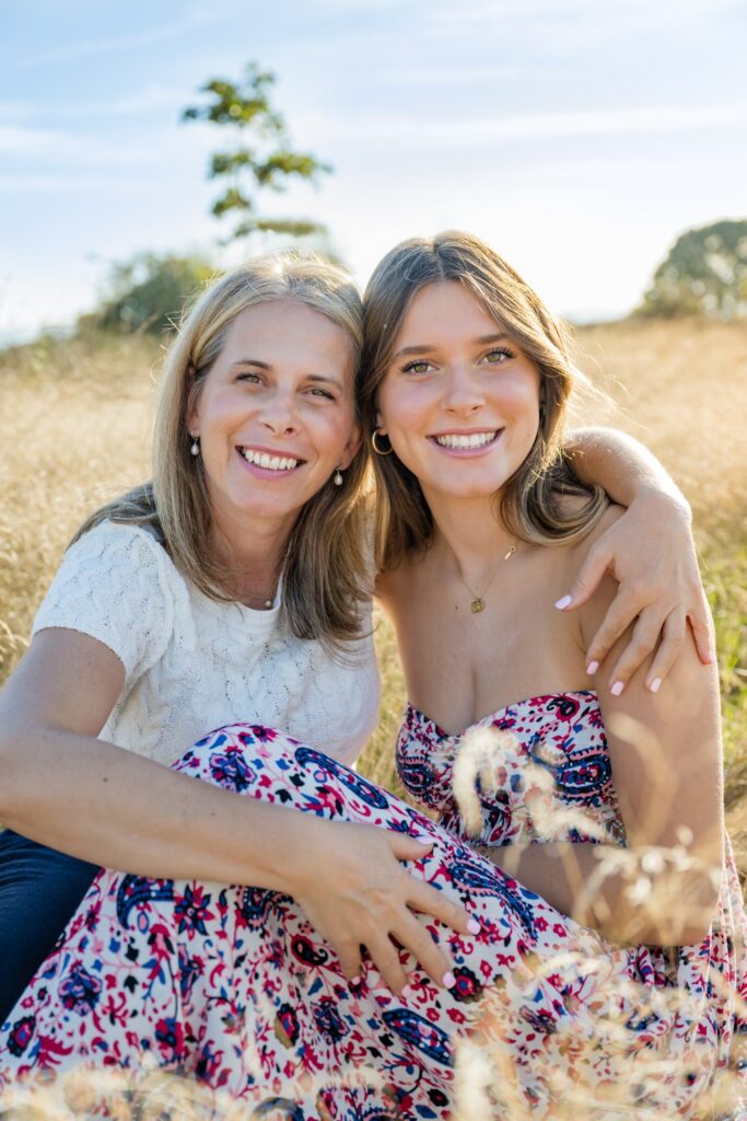 senior and mom seated pose open field