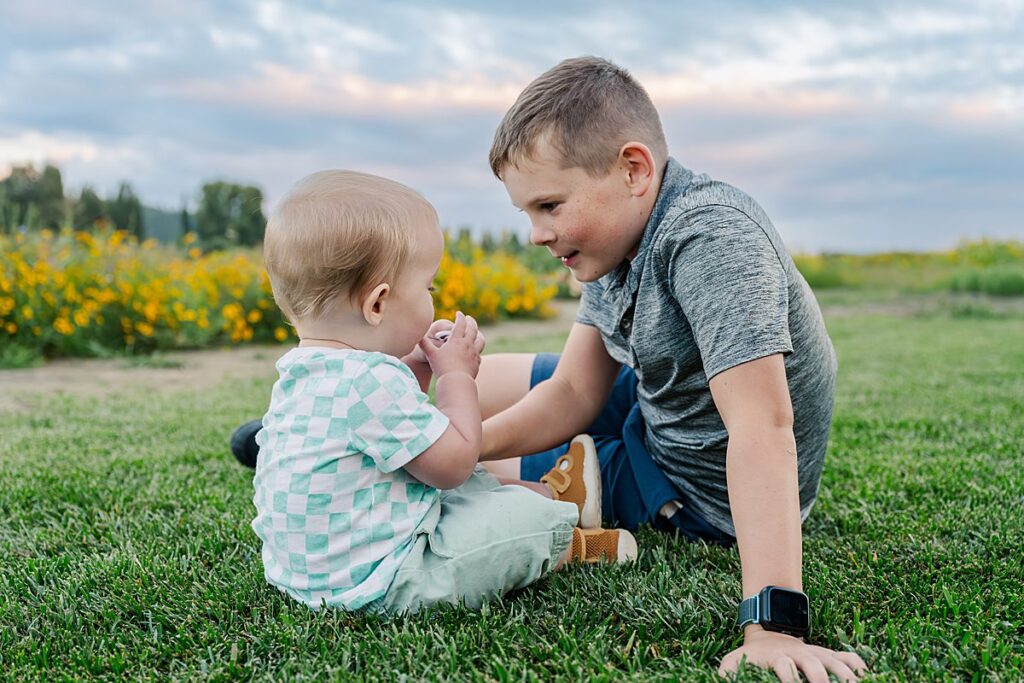 baby and boy on grass portrait