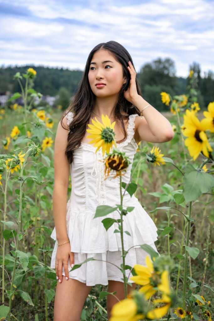 white dress high school senior in sunflower field