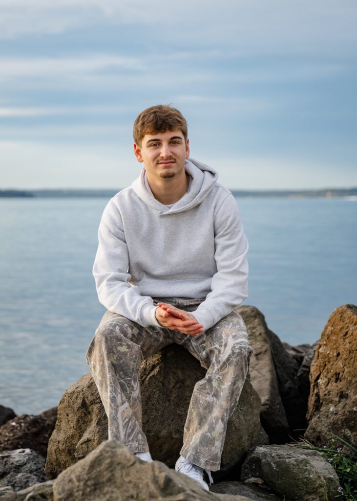 boy sitting on rock at discovery park seattle