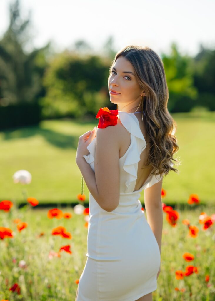 high school senior girl white dress in poppy field at pine creek nursery