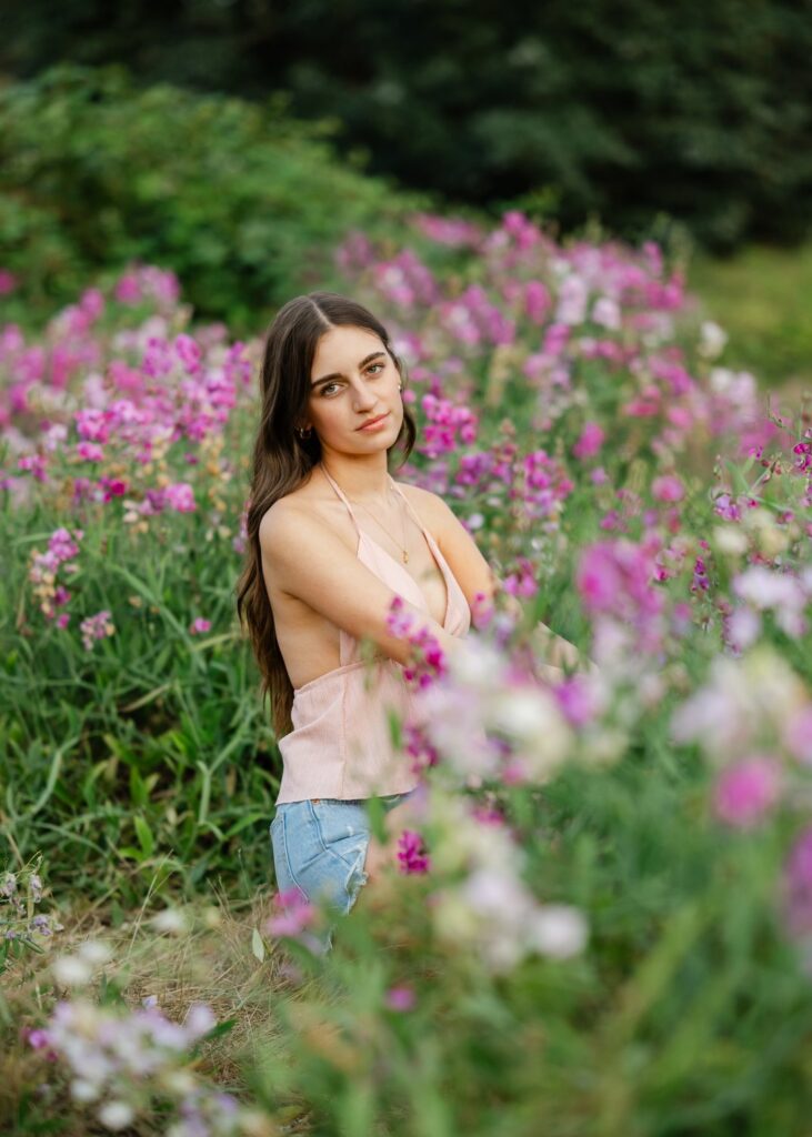senior girl at discovery park sitting in sweet pea wildflower field