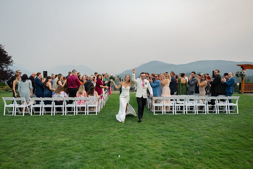 The Club at Snoqualmie Ridge wedding venue bride and groom celebrate walking down aisle 